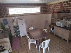 a kitchen with a table and chairs in a kitchen at Casa Centro de Maragogi in Maragogi