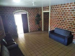 a room with a brick wall and a blue couch at Casa Centro de Maragogi in Maragogi