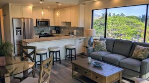 a living room with a couch and a kitchen at Papakea #H401 in Lahaina