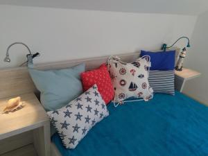 a bunch of pillows sitting on a bed at Domki Ancora - komfortowe domki nad morzem in Jastrzębia Góra