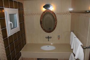 a bathroom with a sink and a mirror at Athorama Hotel in Ouranoupoli +16 photos