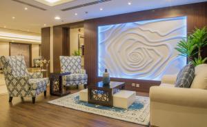 达曼نورمينا الشرق للشقق المخدومة的大堂设有两把椅子和大屏幕