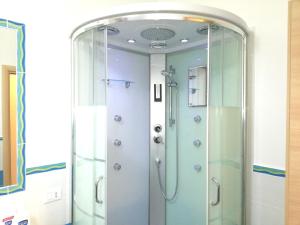 a shower in a bathroom with a mirror at Capo d'Orlando Apartments in Capo dʼOrlando +75 photos