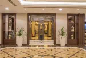 a lobby of a hotel with two potted plants at Normina Hotel Suites in Dammam