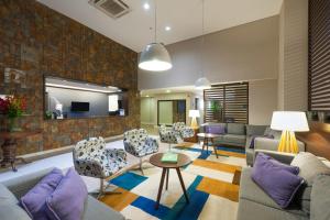 a living room with a couch and chairs and a table at Matiz Multi Suites in Duque de Caxias