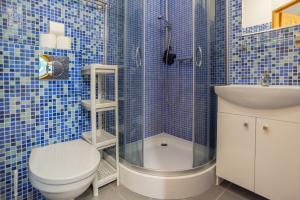 a blue tiled bathroom with a toilet and a sink at Hubertus Rewal in Rewal +56 photos