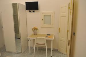 een kleine witte tafel met twee stoelen en een spiegel bij Archivio dei Ricordi - Casa con vista a Ostuni in Ostuni