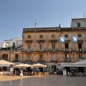 a large building with tables and chairs in front of it at Archivio dei Ricordi - Casa con vista a Ostuni in Ostuni