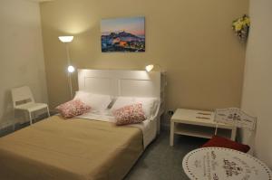 a small bedroom with a bed and a table at Archivio dei Ricordi - Casa con vista a Ostuni in Ostuni
