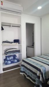 a white room with two beds and a mirror at Unlimited Ocean Front in Santos
