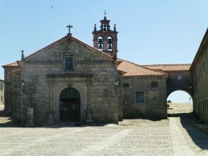 an old stone church with a clock tower at Casa Serra da Lapa in Viseu