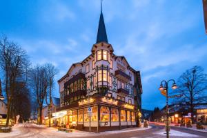 a large building with a steeple on a street at Hotel Victoria in Bad Harzburg