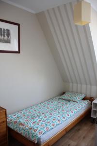 łóżko w pokoju z sufitem o paskach w obiekcie Nella w mieście Darłowo