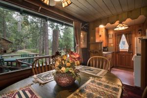 a dining room with a table and a kitchen with a window at 14 Chipmunk Hollow in Wawona