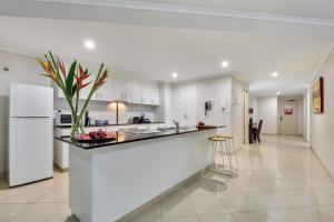 a kitchen with a counter and a white refrigerator at Argus Apartments Darwin in Darwin