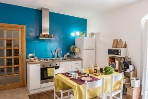 a kitchen with a table and a blue wall at B.I.C. (bnb in centro) in Sassari