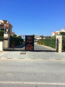 un cartello su una recinzione di fronte a una casa di Pyla Village Resort F110 (Apartment near Larnaca) a Pyla