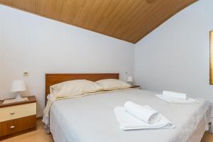 a bedroom with a bed with white towels on it at Apartment Miranda in Malinska