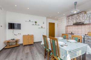 a kitchen and dining room with a table and chairs at Apartment Miranda in Malinska