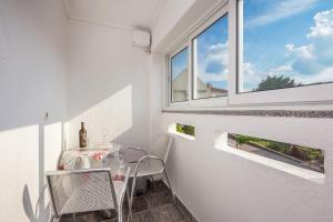a small balcony with a table and a window at Apartment Miranda in Malinska +9 photos