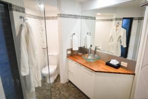 ein Badezimmer mit einem Waschbecken, einem WC und einem Spiegel in der Unterkunft The Boathouse in Yamba