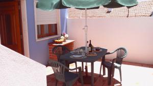 ヴィラ・ノヴァ・デ・ミルフォンテスにあるBLUE HOUSE by Stay in Alentejoのテーブル、椅子、パラソルが備わります。