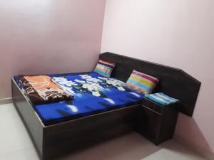 uma pequena cama com um edredão e almofadas azuis em Hotel Blue Heaven em Fatehpur Sīkri