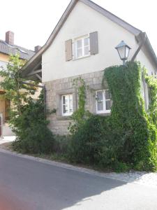 a house with ivy growing on the side of it at Apartments Bed & Breakfast Brückner in Willanzheim