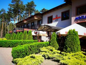 a building with bushes and an umbrella in front of it at Santana Club in Wielen Zaobrzanski