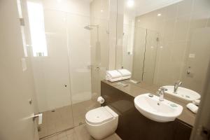 a bathroom with a toilet, sink, and shower at Hotel Bondi in Sydney