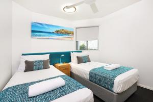 En eller flere senger på et rom på Malibu Apartments
