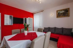 - une salle à manger rouge avec une table et un canapé dans l'établissement House Josipa, à Trogir