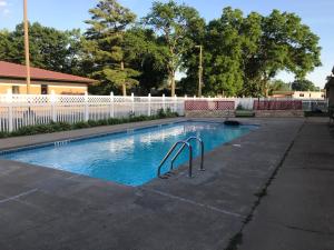 a swimming pool in a yard with a white fence at Best Nights Inn - Sparta in Sparta