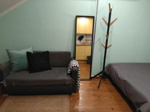 uma sala de estar com um sofá e um espelho em Cactus House Lisboa em Lisboa