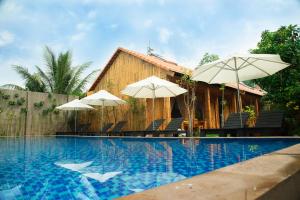 a swimming pool with umbrellas and a house at Ong Lang Garden Resort in Phu Quoc +29 photos