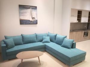 a living room with a blue couch and a table at Casa Bella Deluxe Apartments in Palaiochora