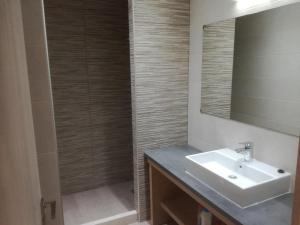a bathroom with a sink and a shower with a mirror at Casa Bella Deluxe Apartments in Palaiochora