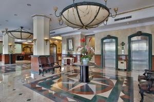 雅加達的住宿－雅加達查雅加達酒店，大堂配有桌椅和吊灯。