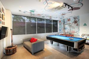 a living room with a pool table and a couch at BATIQA Hotel Jababeka Cikarang in Cikarang