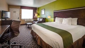 a hotel room with a large bed and a television at SureStay Hotel by Best Western Floresville in Floresville +9 photos