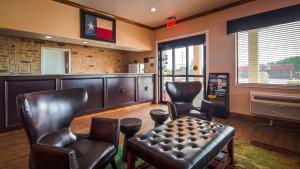 a barbershop with leather chairs and a table and a barber shop at SureStay Hotel by Best Western Floresville in Floresville