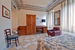 una camera con letto, sedia e scrivania di Al Mercato B&B a Siena