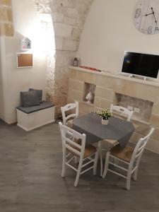 une salle à manger avec une table, des chaises et une cheminée dans l'établissement La Casedda di pittali, à Carovigno