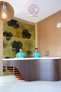 two men standing at a counter in a room at FixOn Capsule Hotel in Purwokerto