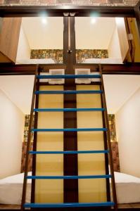 a ladder leading up to a bunk bed at FixOn Capsule Hotel in Purwokerto