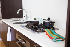 a kitchen with a stove with a pot and pans on it at Alpen Ridge in Niseko