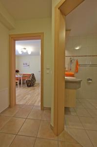 a bathroom with a walk in shower and a dining room at Alpine Spa Residence in Bad Kleinkirchheim