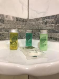 three products sitting on top of a bathroom sink at Hotel Sutter in Sutter Creek