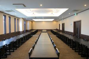 an empty room with rows of tables and chairs at Ofunato Onsen in Ōfunato +40 photos