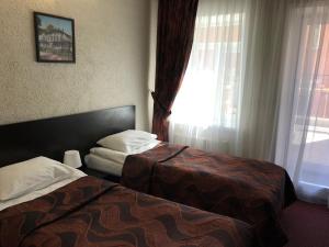 
a hotel room with two beds and two lamps at Podvorye Hotel in Tula
